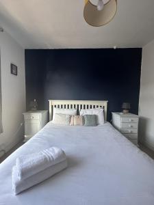 a bedroom with a large white bed with a blue wall at Serene Bristol Home with Sunny Patio Garden in Bristol