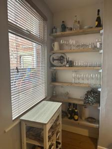 una habitación con una mesa y estanterías con gafas en Serene Bristol Home with Sunny Patio Garden en Bristol