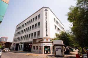 un edificio blanco con un cartel en el costado en Hotel Centria en Monterrey