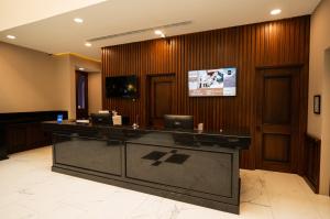 a lobby with a reception desk with a tv on the wall at Hotel Centria in Monterrey