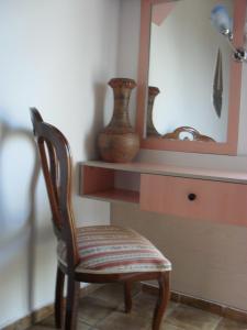 a chair sitting in front of a desk with a mirror at La Santre Villa in Amoudara Herakliou