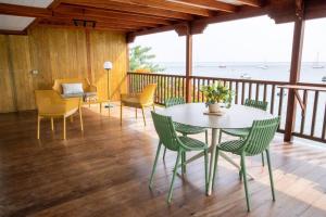 a dining room with a table and chairs on a deck at Ti Chill, appartement 3 pièces neuf front de mer in Les Anses-dʼArlets