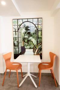 a white table with two chairs and a window at Ti Chill, appartement 3 pièces neuf front de mer in Les Anses-dʼArlets