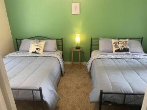 a bedroom with two beds and a table with a lamp at Classy, Spacious 1King2Full House in the Center of Norman in Norman