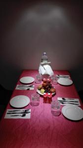 - une table rouge avec des assiettes et des ustensiles dans l'établissement B&B Diec10, à Murta Maria