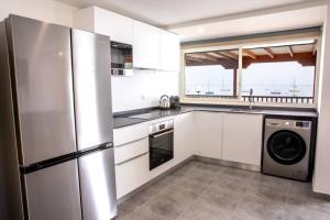 a kitchen with a stainless steel refrigerator and a dishwasher at Ti Chill, appartement 3 pièces neuf front de mer in Les Anses-dʼArlets