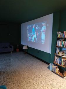 a large projection screen in a room with a book shelf at La Bonita Guesthouse in Bucaramanga
