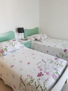 two beds sitting next to each other in a bedroom at A Torre in Sarria
