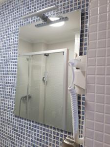 a mirror in a bathroom with a shower and a sink at A Torre in Sarria