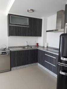 a kitchen with wooden cabinets and a sink at A Torre in Sarria +10 photos