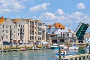 a boat is docked in a harbor with buildings at Townbridge Penthouse in Weymouth