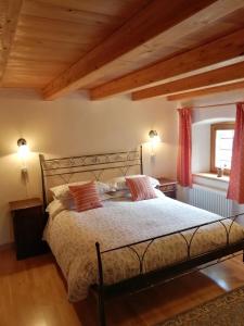 a bedroom with a large bed with wooden ceilings at La Thuillettaz B&B in Saint-Rhémy-en-bosses
