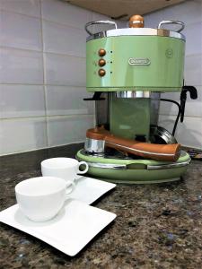 a green coffee maker with two cups on a counter at Prime Location! Detached Clifton Home with Parking in Bristol +21 photos