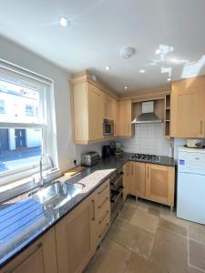 a kitchen with wooden cabinets and a sink and a window at Prime Location! Detached Clifton Home with Parking in Bristol