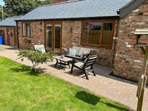 un patio con mesa y bancos frente a un edificio en The Annexe en Bridlington