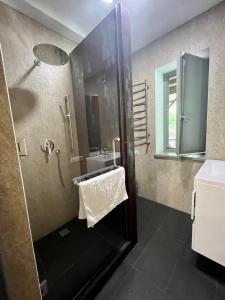 uma casa de banho com um chuveiro e um lavatório. em Hygge em Tatariv