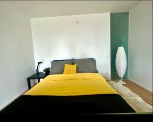 a bedroom with a large bed with a yellow blanket at Sunset Apartment Vienna in Vienna