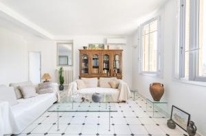 a white living room with a couch and a table at Splendide vue sur ND de la Garde et le Vieux Port in Marseille