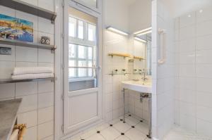 uma casa de banho branca com um lavatório e uma janela em Splendide vue sur ND de la Garde et le Vieux Port em Marselha