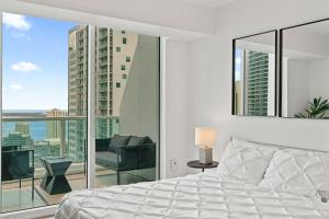 a bedroom with a bed and a large window at Skyline Serenity - Brickell On The River 1901 - Bi-Level Loft with Breathtaking Views On The Ocean in Miami