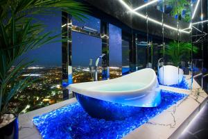 a bathroom with a tub on a counter with blue rocks at Apartamenty Sky Tower z Wanna Przy Oknie in Wrocław