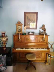 ein hölzernes Klavier mit einer Uhr darüber in der Unterkunft Angelos' Αrt Αpartment in Athen