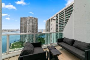a living room with a couch and chairs on a balcony at Skyline Serenity - Brickell On The River 1901 - Bi-Level Loft with Breathtaking Views On The Ocean in Miami