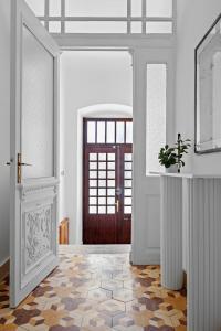 een gang met een deur en een vloer met een plant bij White Imperial Apartment in Pula