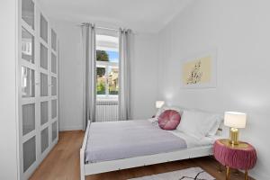 een witte slaapkamer met een bed en een raam bij White Imperial Apartment in Pula