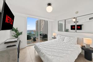 a bedroom with a white bed and a large window at Skyline Serenity - Brickell On The River 1901 - Bi-Level Loft with Breathtaking Views On The Ocean in Miami