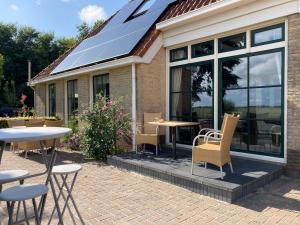 une maison avec des panneaux solaires sur le toit dans l'établissement B&B Stations Koffiehuis, à Molkwerum