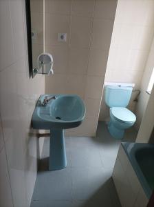 a bathroom with a blue sink and a toilet at El Ferial in Sarón