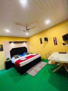 a bedroom with a large bed and a table at Fab Valley Homestay in Munnar