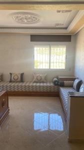 a living room with a couch and a window at Big appartement in ksar sgher and close in Ksar es Sghir