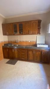 a kitchen with wooden cabinets and a laptop on a counter at Big appartement in ksar sgher and close in Ksar es Sghir