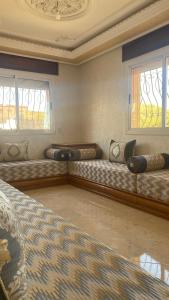 a room with three beds and two windows at Big appartement in ksar sgher and close in Ksar es Sghir