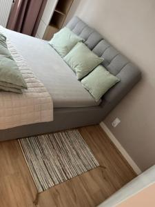 ein Bett mit Kissen und einem Teppich in einem Schlafzimmer in der Unterkunft Apartament Mieszczański Klima-ParkigFree2x-Netflix-YouTube in Breslau