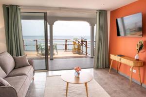 un soggiorno con un divano e un tavolo di TI PUNCH, appartement 3 pièces neuf, front de mer a Les Anses-d'Arlets