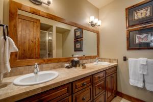 a bathroom with two sinks and a large mirror at The Porches in Steamboat Springs