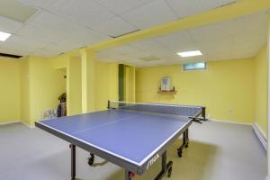 a ping pong table in a room with yellow walls at Sparrow Bush Retreat with Fireplace and Screened Porch in Sparrow Bush