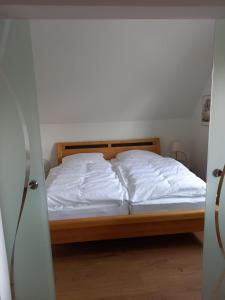 1 dormitorio con 1 cama con sábanas blancas en Ferienwohnung Klein & Fein en Güstrow