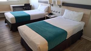 Habitación de hotel con 2 camas y teléfono en Hotel Diego de Almagro Calama Express, en Calama