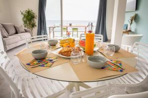 una mesa de comedor con comida encima en Ti soleil, appartement 3 pièces neuf, front de mer, en Les Anses-dʼArlet