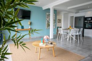 a living room with a table and a kitchen at Ti soleil, appartement 3 pièces neuf, front de mer in Les Anses-dʼArlets