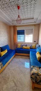 un salon avec des canapés bleus et un plafond dans l'établissement appartement à louer saidia, à Saïdia