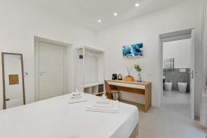 a white bedroom with a desk and a bed at Grenni Guesthouse in La Spezia