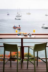 a table with two chairs and a view of the water at Ti soleil, appartement 3 pièces neuf, front de mer in Les Anses-dʼArlets