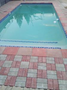 a swimming pool with a tiled floor and a swimming pool at PS GOOD TIME GUEST HOUSE in Klerksdorp