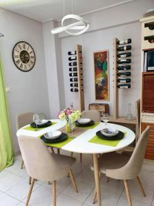 a dining room table with chairs and a clock on the wall at Modern 2BR city flat 10min from the beach in Athens +48 photos