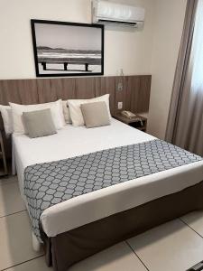 a bedroom with a large bed in a room at Oasis Cabo Frio in Cabo Frio